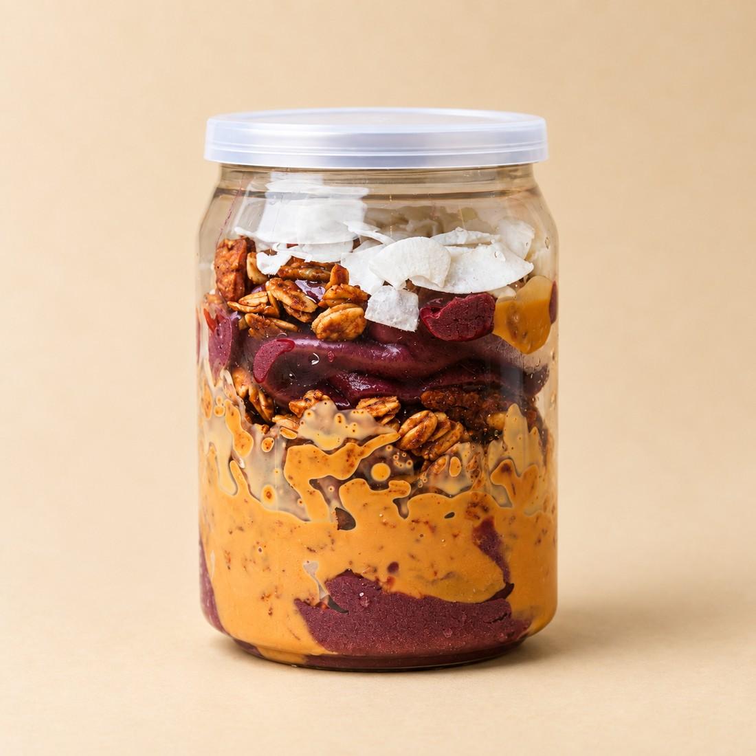 Acai Nutty Peanut in a clear jar on a cream studio background