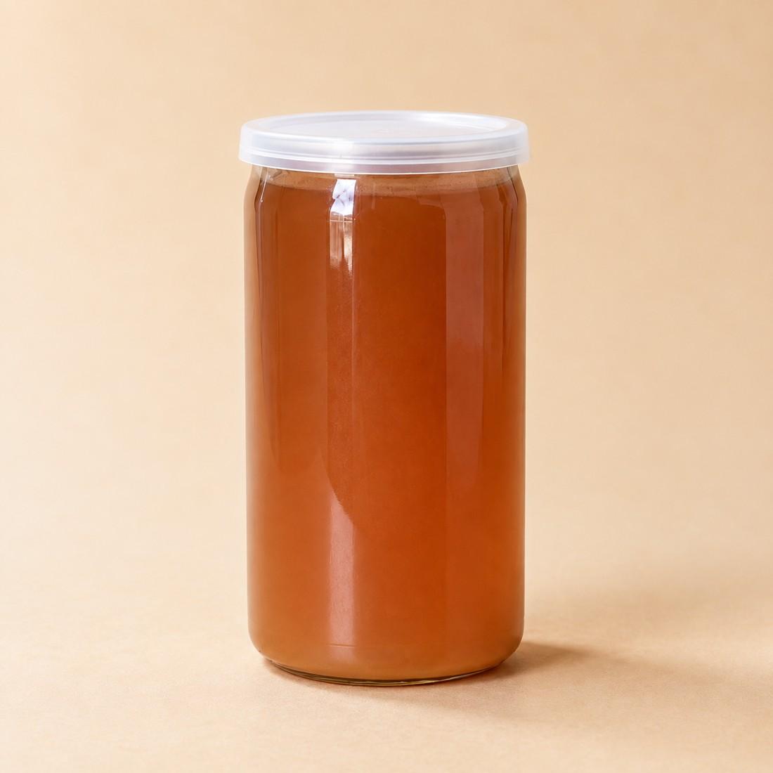 Amber cold-brewed tea and coffee drink in a clear can-style cup