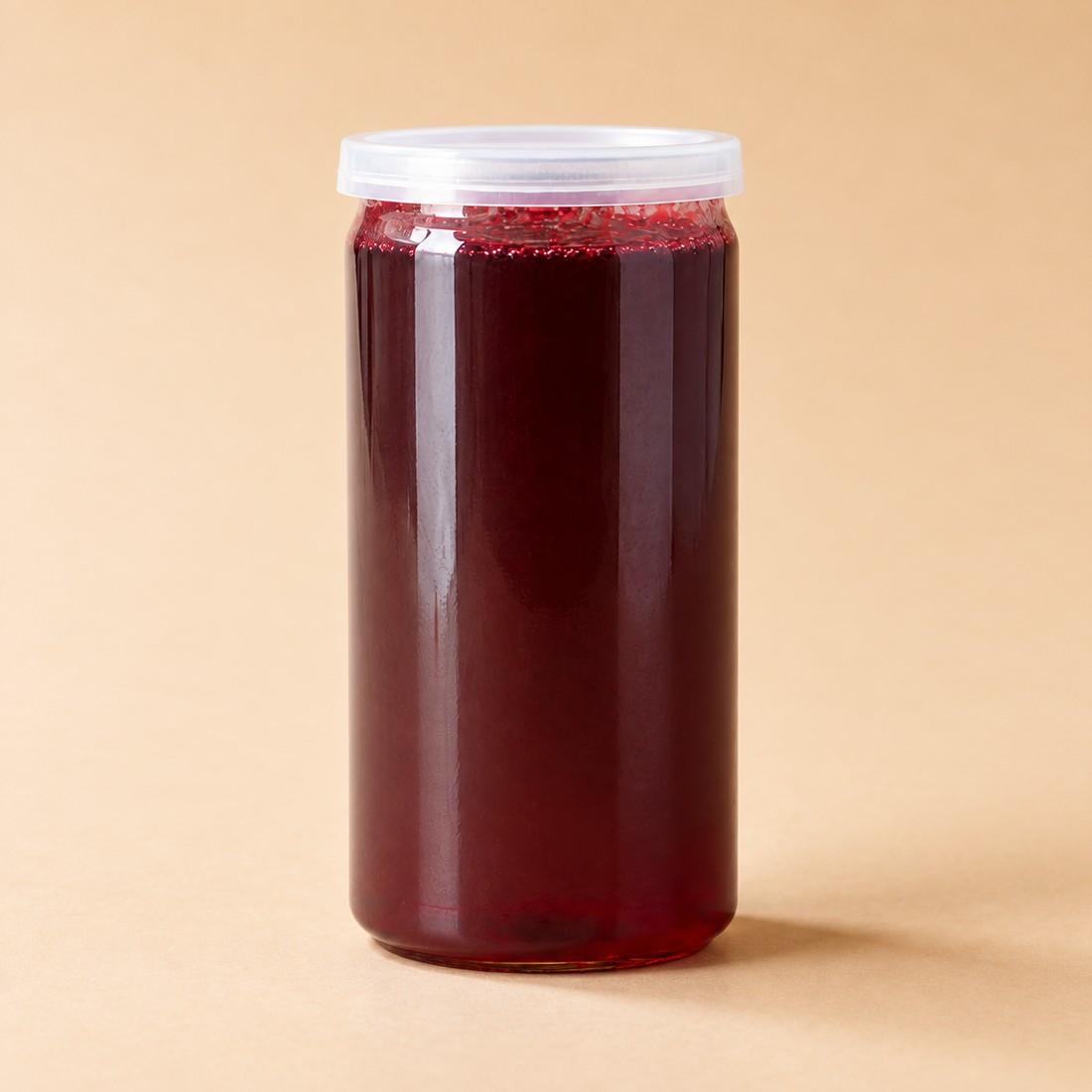 Ruby-red hibiscus and strawberry iced tea in a clear can-style cup