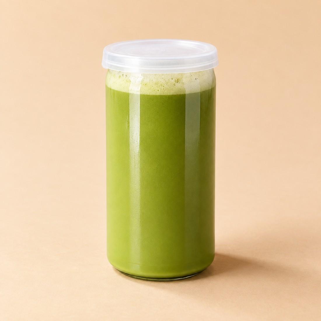 Green matcha drink topped with pale salted vanilla foam in a clear can-style cup