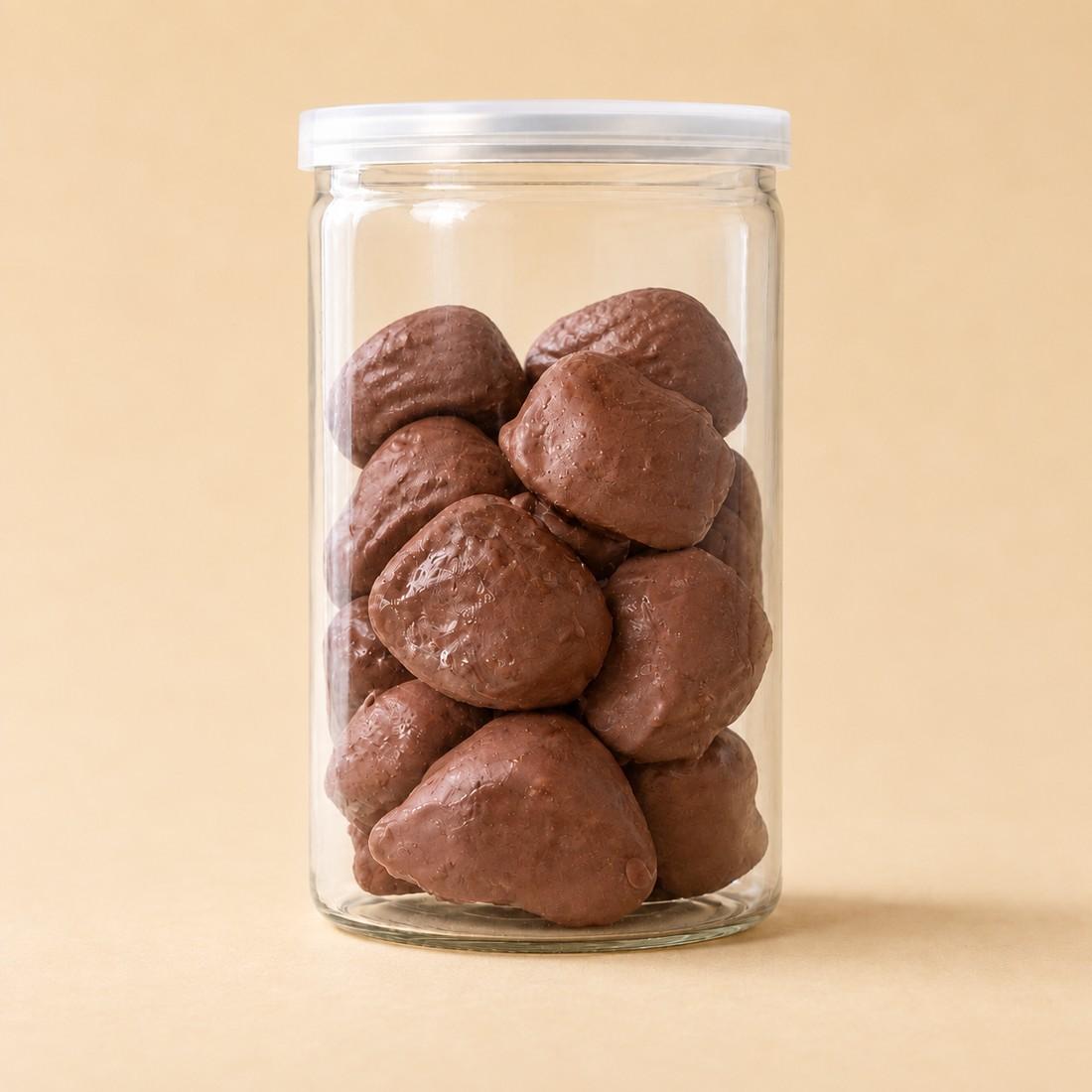 Chocolate-brown raspberry dome bites arranged in a clear CRMY confectionery jar