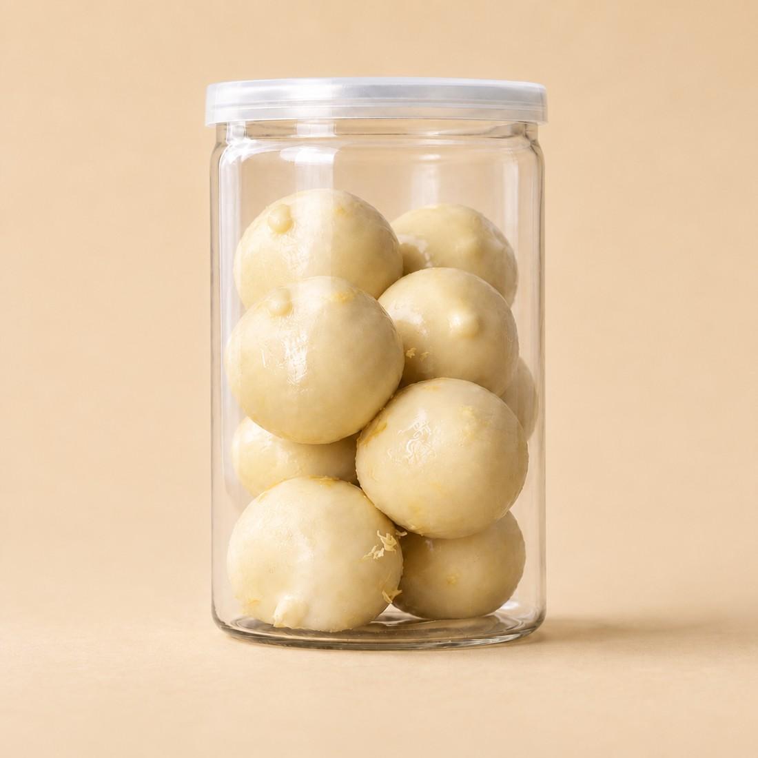 Pale lemon protein bites arranged in a clear CRMY confectionery jar